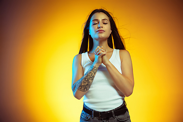 Image showing Portrait of young caucasian woman isolated on gradient yellow studio background