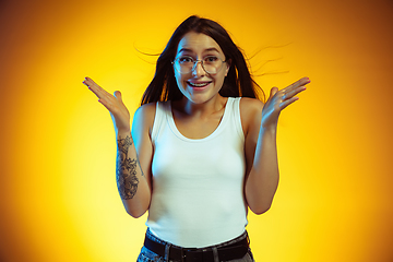 Image showing Portrait of young caucasian woman isolated on gradient yellow studio background