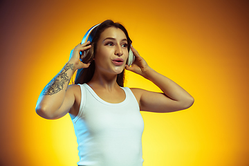 Image showing Portrait of young caucasian woman isolated on gradient yellow studio background