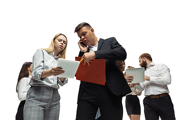 Image showing Nervous tensioned investors analyzing crisis stock market with charts on screen of their gadgets