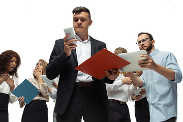 Image showing Nervous tensioned investors analyzing crisis stock market with charts on screen of their gadgets