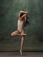 Image showing Young graceful tender ballerina on dark green studio background