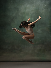 Image showing Young graceful tender ballerina on dark green studio background