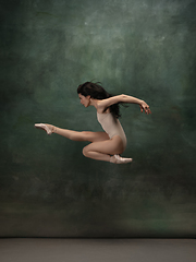 Image showing Young graceful tender ballerina on dark green studio background