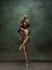 Image showing Young graceful tender ballerina on dark green studio background