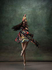 Image showing Young graceful tender ballerina on dark green studio background