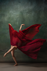 Image showing Young graceful tender ballerina on dark green studio background