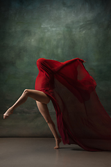 Image showing Young graceful tender ballerina on dark green studio background