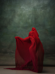 Image showing Young graceful tender ballerina on dark green studio background