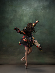 Image showing Young graceful tender ballerina on dark green studio background