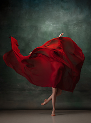 Image showing Young graceful tender ballerina on dark green studio background