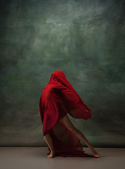 Image showing Young graceful tender ballerina on dark green studio background