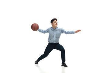 Image showing Man in office clothes playing basketball on white background. Unusual look for businessman in motion, action. Sport, healthy lifestyle.