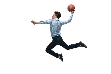Image showing Man in office clothes playing basketball on white background. Unusual look for businessman in motion, action. Sport, healthy lifestyle.