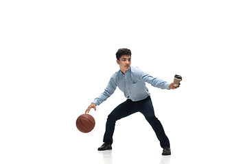 Image showing Man in office clothes playing basketball on white background. Unusual look for businessman in motion, action. Sport, healthy lifestyle.