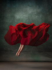 Image showing Young graceful tender ballerina on dark green studio background