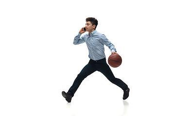 Image showing Man in office clothes playing basketball on white background. Unusual look for businessman in motion, action. Sport, healthy lifestyle.