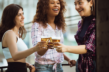 Image showing Group of happy friends having beer party in summer day. Resting together outdoor, celebrating and relaxing, laughting. Summer lifestyle, friendship concept.