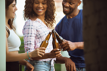 Image showing Group of happy friends having beer party in summer day. Resting together outdoor, celebrating and relaxing, laughting. Summer lifestyle, friendship concept.