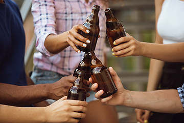 Image showing Group of happy friends having beer party in summer day. Resting together outdoor, celebrating and relaxing, laughting. Summer lifestyle, friendship concept.