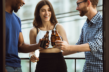 Image showing Group of happy friends having beer party in summer day. Resting together outdoor, celebrating and relaxing, laughting. Summer lifestyle, friendship concept.