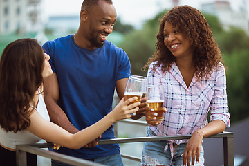 Image showing Group of happy friends having beer party in summer day. Resting together outdoor, celebrating and relaxing, laughting. Summer lifestyle, friendship concept.