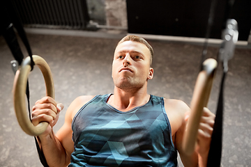 Image showing man doing exercising on gymnastic rings in gym