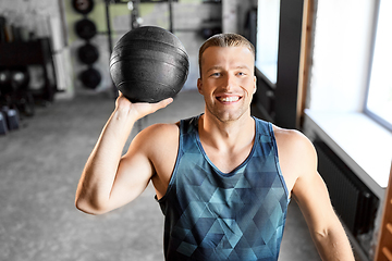 Image showing happy smiling young man with medicine ball in gym