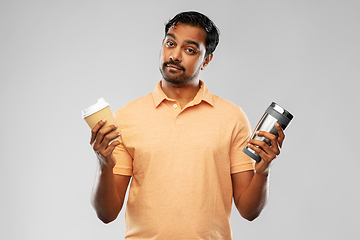 Image showing man comparing thermo cup or tumbler and coffee cup