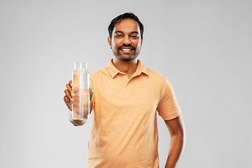 Image showing happy indian man showing water in glass bottle