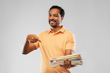 Image showing smiling young indian man sorting paper waste