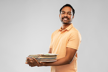 Image showing smiling young indian man sorting paper waste