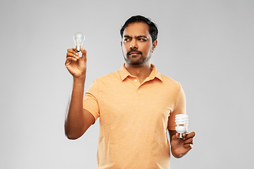 Image showing indian man comparing different light bulbs