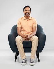 Image showing happy smiling young indian man sitting in chair