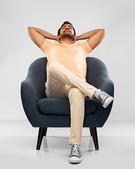 Image showing happy smiling young indian man sitting in chair