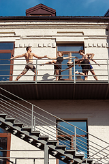 Image showing The group of modern ballet dancers performing on the stairs at the city