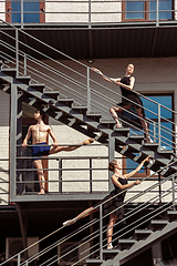 Image showing The group of modern ballet dancers performing on the stairs at the city