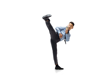 Image showing Man in office clothes practicing taekwondo on white background. Unusual look for businessman in motion, action. Sport, healthy lifestyle.