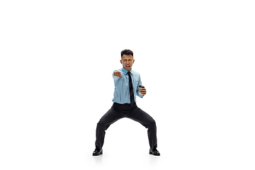 Image showing Man in office clothes practicing taekwondo on white background. Unusual look for businessman in motion, action. Sport, healthy lifestyle.