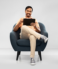 Image showing happy indian man with tablet pc computer in chair