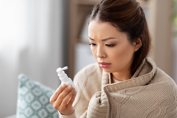 Image showing sick asian woman with oral spray medicine at home