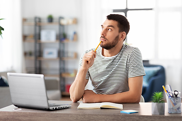 Image showing man with notebook and laptop at home office