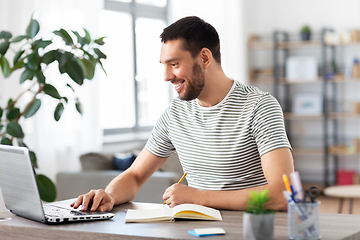 Image showing man with notebook and laptop at home office