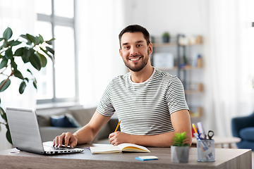 Image showing man with notebook and laptop at home office