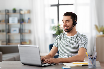 Image showing man with headset and laptop working at home