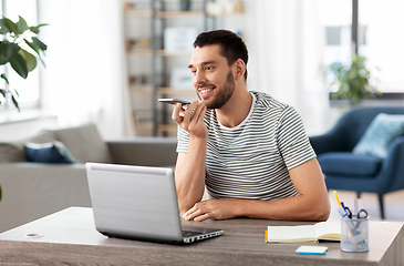 Image showing man with laptop calling on phone at home office