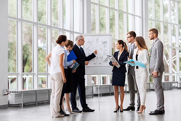 Image showing business team with scheme on flip chart at office