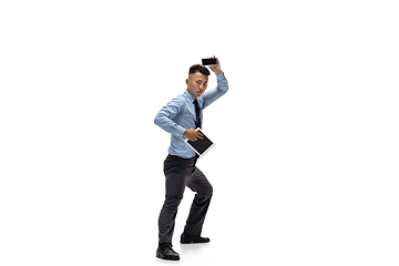 Image showing Man in office clothes practicing taekwondo on white background. Unusual look for businessman in motion, action. Sport, healthy lifestyle.