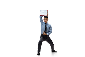 Image showing Man in office clothes practicing taekwondo on white background. Unusual look for businessman in motion, action. Sport, healthy lifestyle.