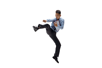 Image showing Man in office clothes practicing taekwondo on white background. Unusual look for businessman in motion, action. Sport, healthy lifestyle.